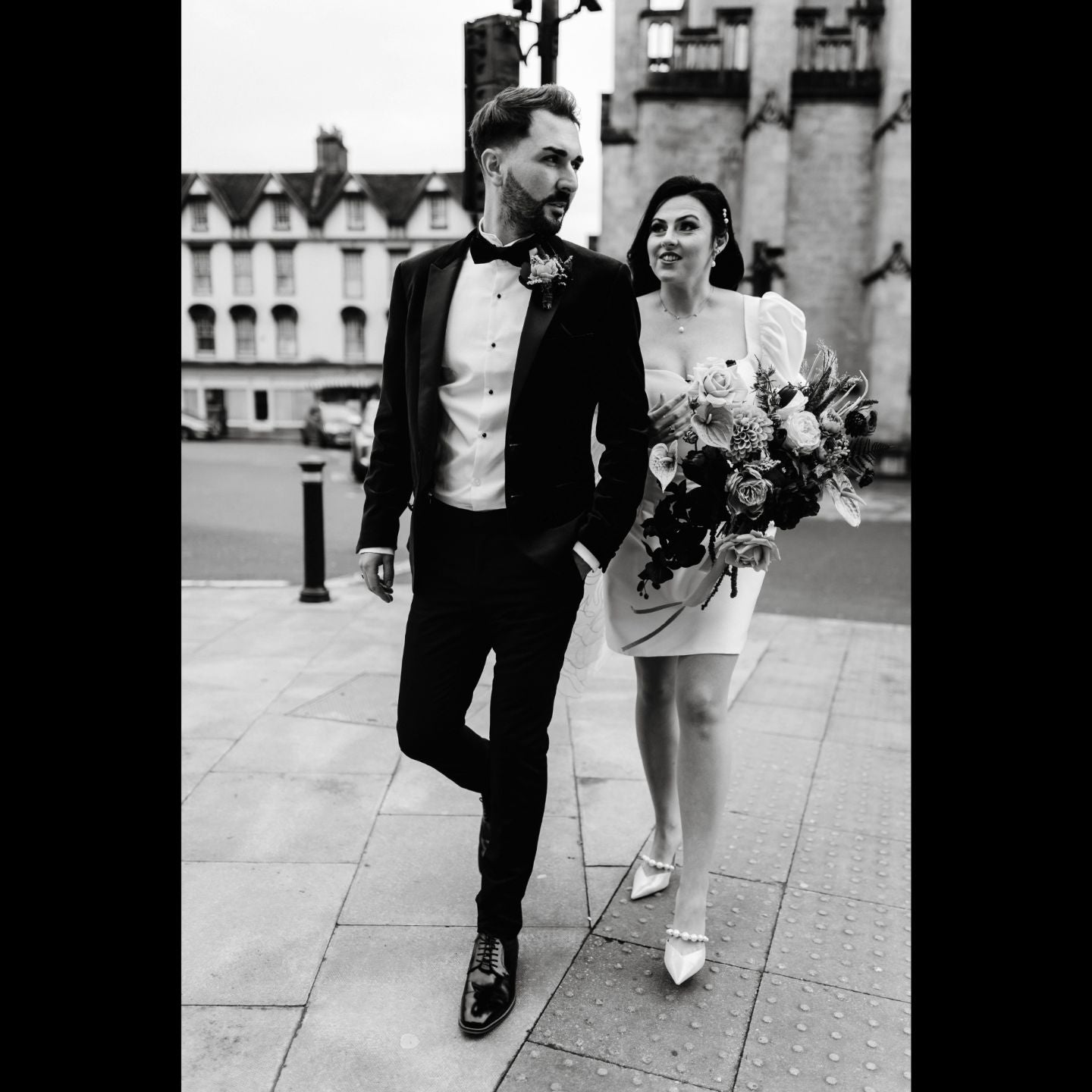 A man and a woman walking down a sidewalk