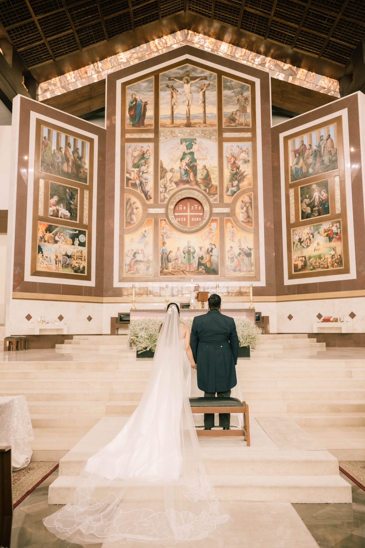 A bride and groom standing at the alter of a church