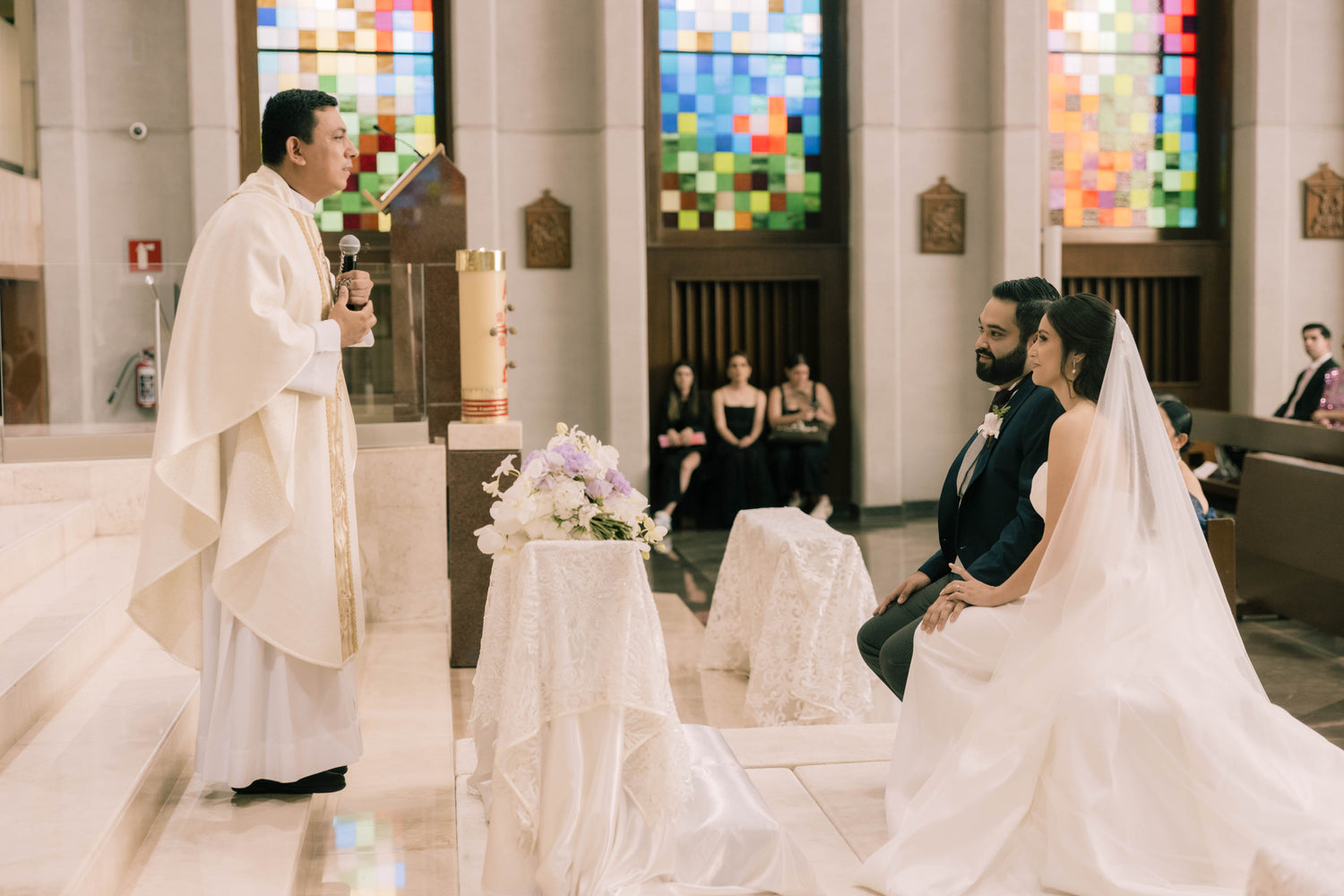 bride and groom sitting at the alter of a church