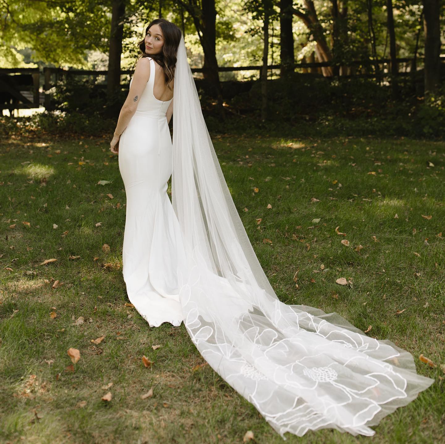 A woman in a wedding dress standing in the grass