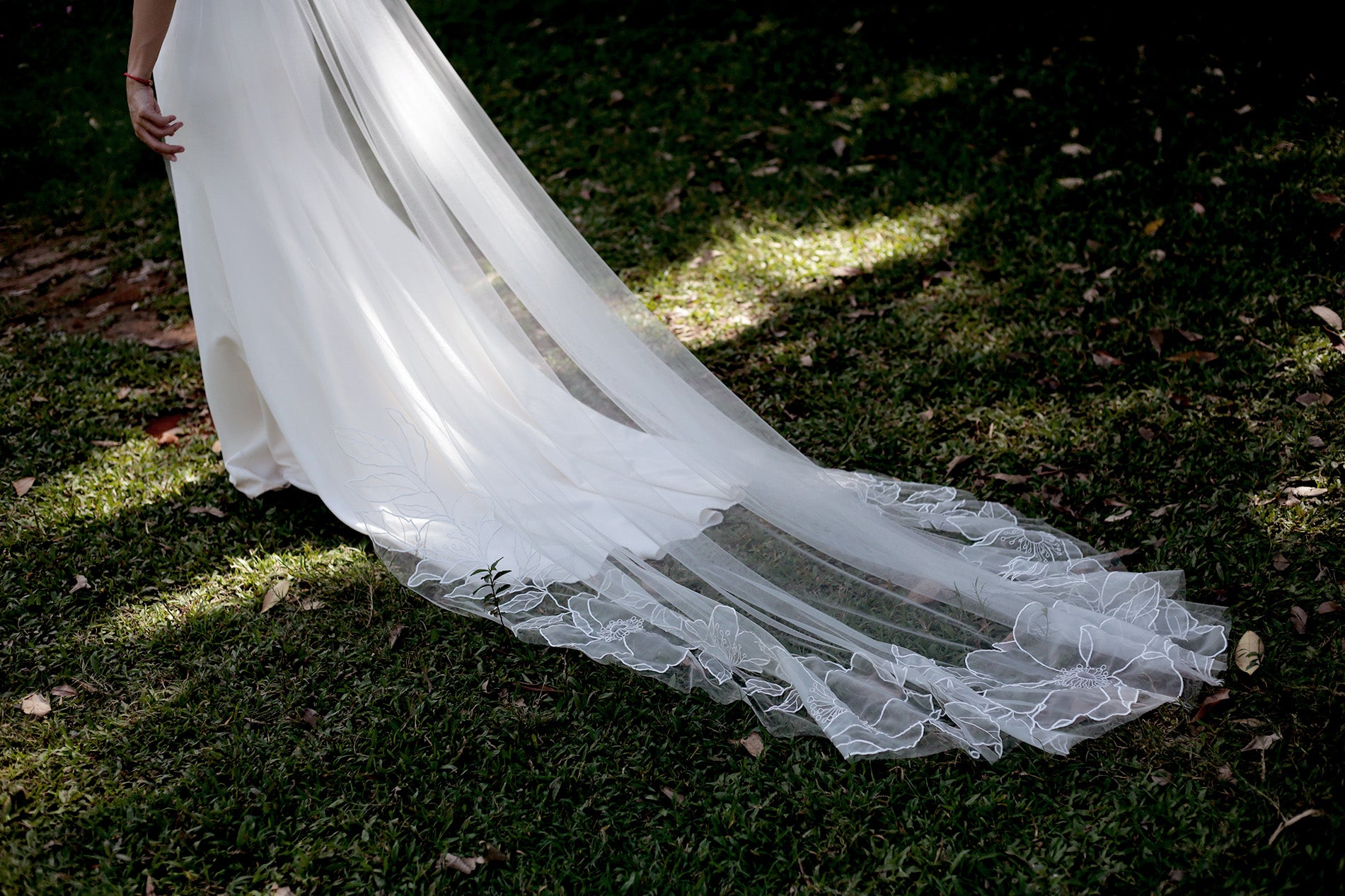 The bottom hem of the SOPHIA cathedral veil, with its beautiful floral embroidery and a wide, flowing train.