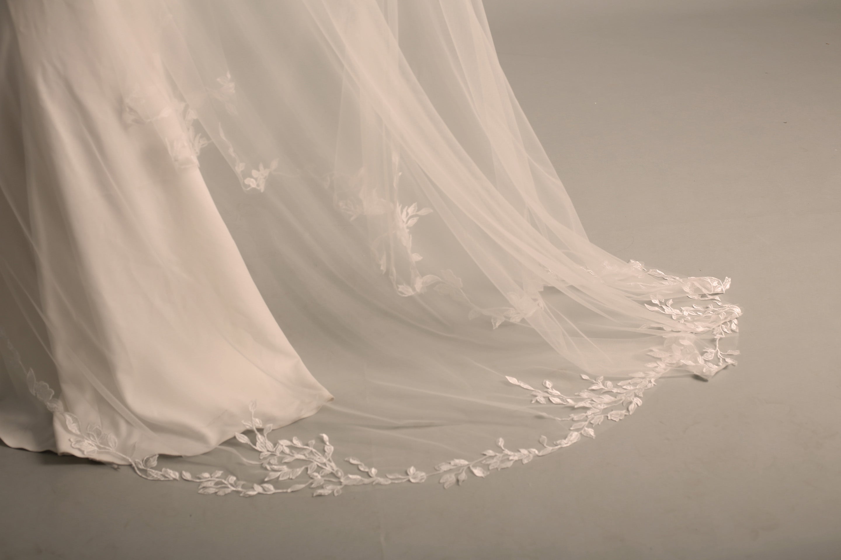 The bottom of the BRITTNIE veil, showcasing the beautiful floral lace and the full, flowing cathedral-length train.
