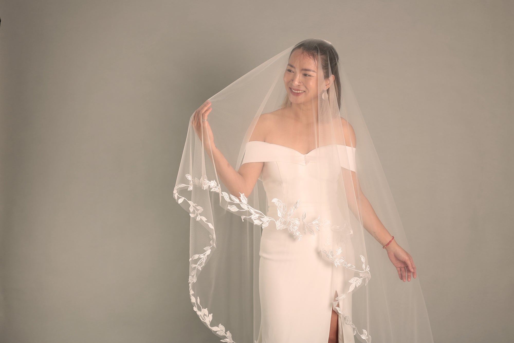 A close-up of the BRITTNIE veil, highlighting the intricate floral lace and the fine texture of the fabric.

