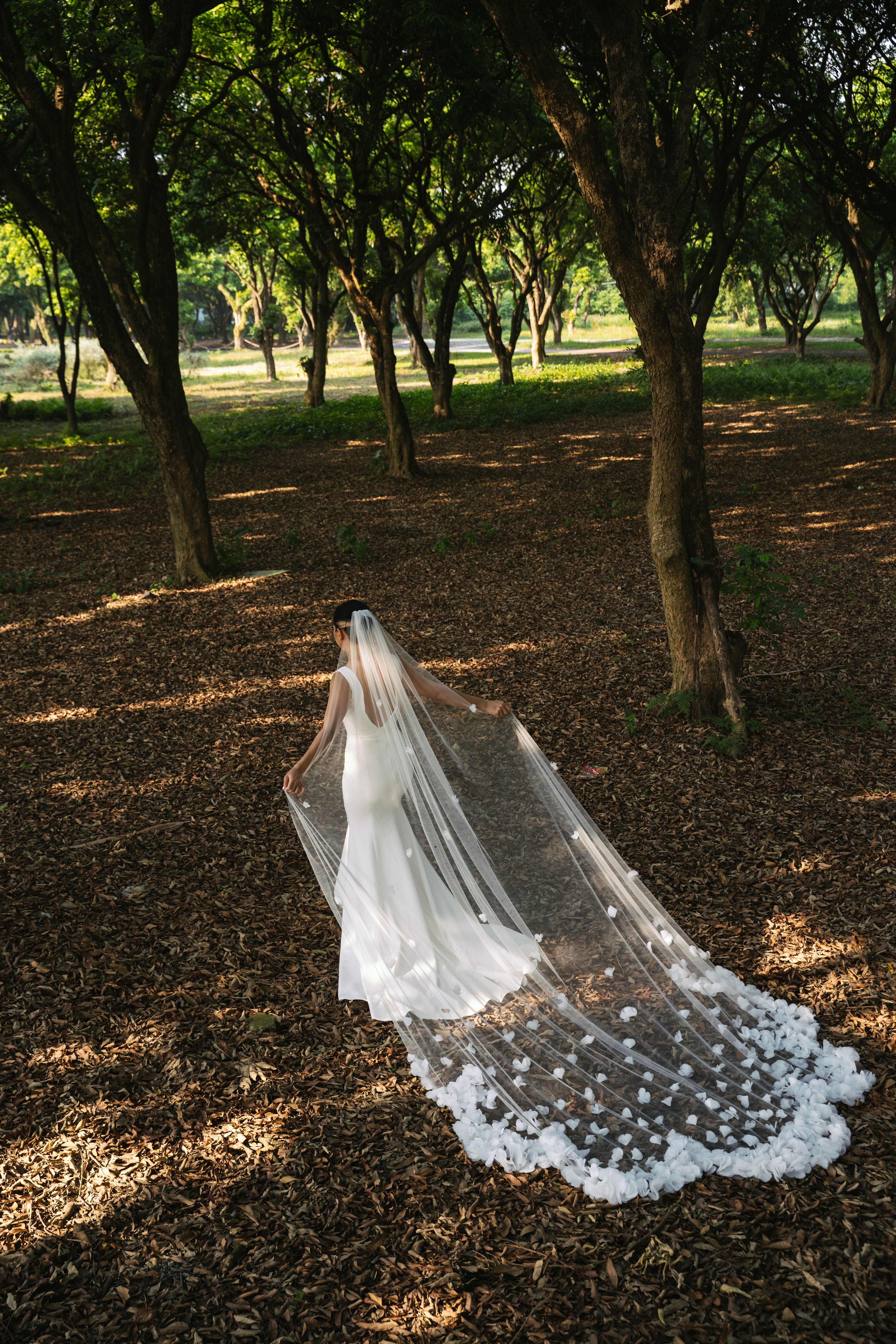 A bride wearing the BELLA wedding veil, showcasing the beautiful three-dimensional floral appliques.


