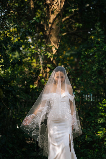 Organza fingertip length wedding veil with blooming floral motifs, handcrafted by Tara Bridal