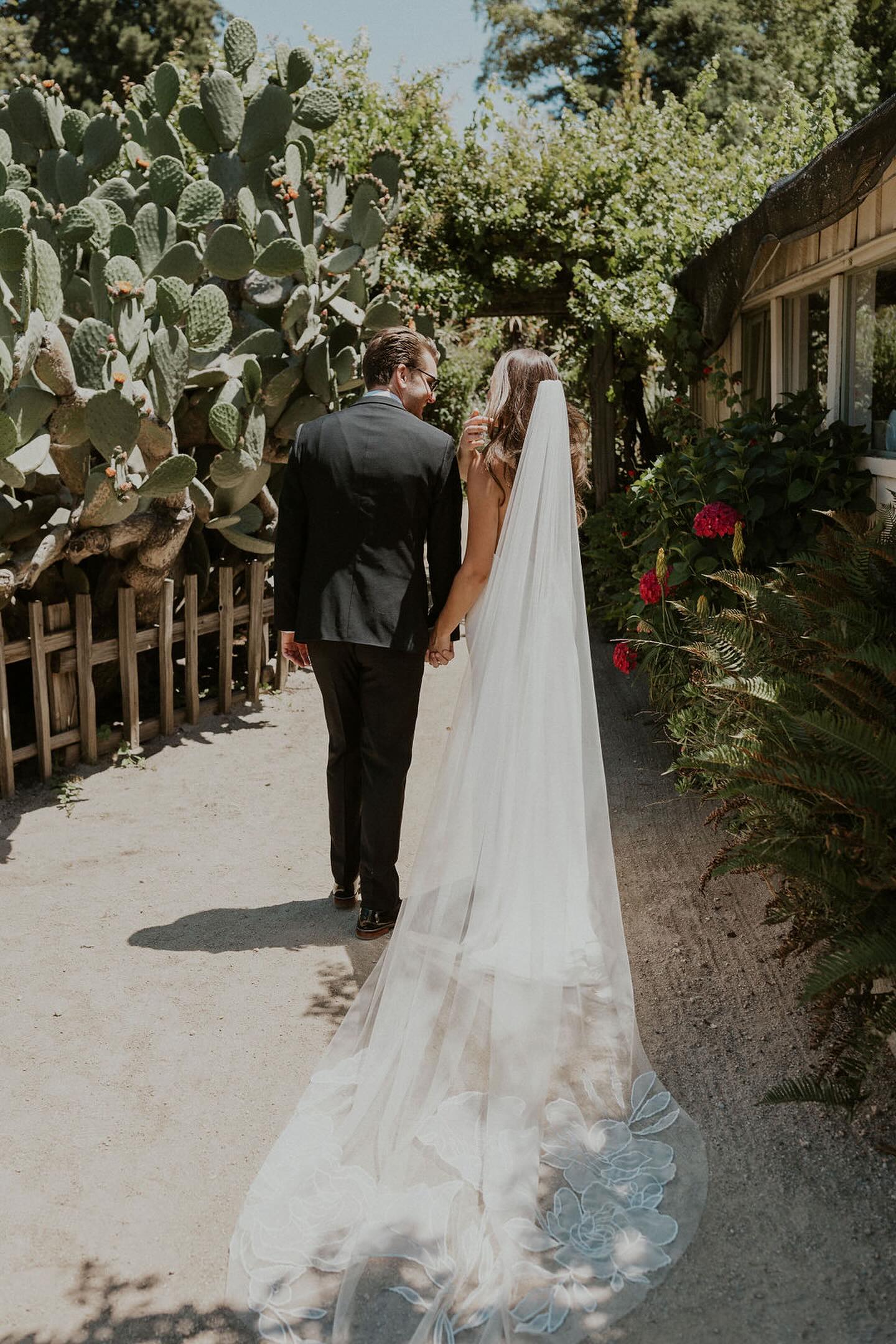 A botanical garden rustic warm and intimate wedding featuring a veil with mix of roses, cosmos, and calla lilies, embroidered onto delicate silk tulle, cathedral length