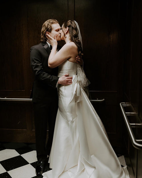 Bride Anna Dietrich with her beaded floral royal cathedral luxury veil kissing her groom in elevator