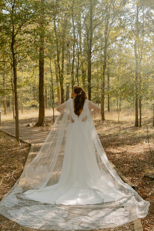 Bride Madeline Ringwald floral cape Kaitie veil in a garden