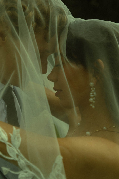 Bride Mckhayla wearing a cathedral-length lace floral veil in a vintage bohemian garden theme wedding
