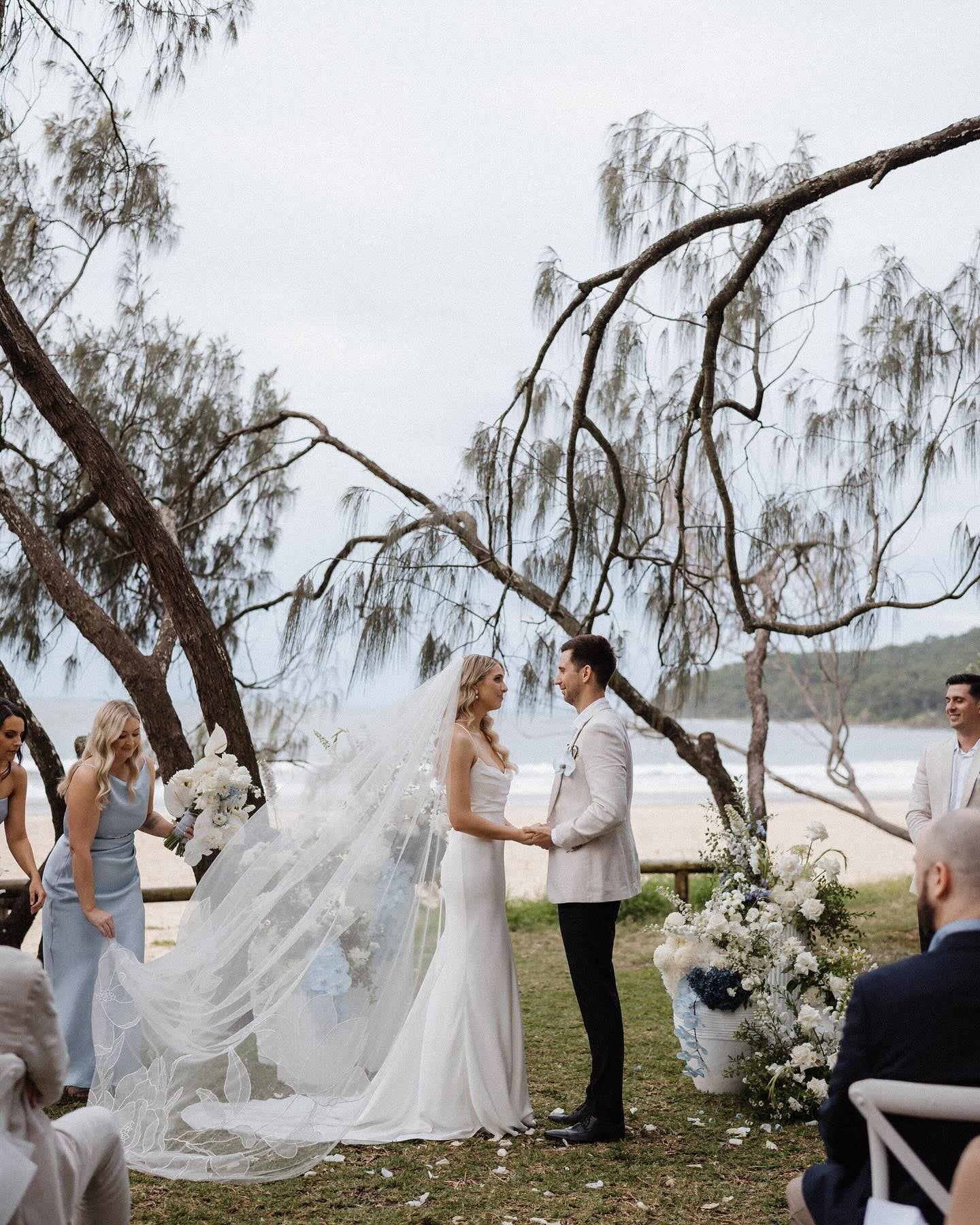 Bride Nicola Fossey with floral cathedra veil on seashore wedding
