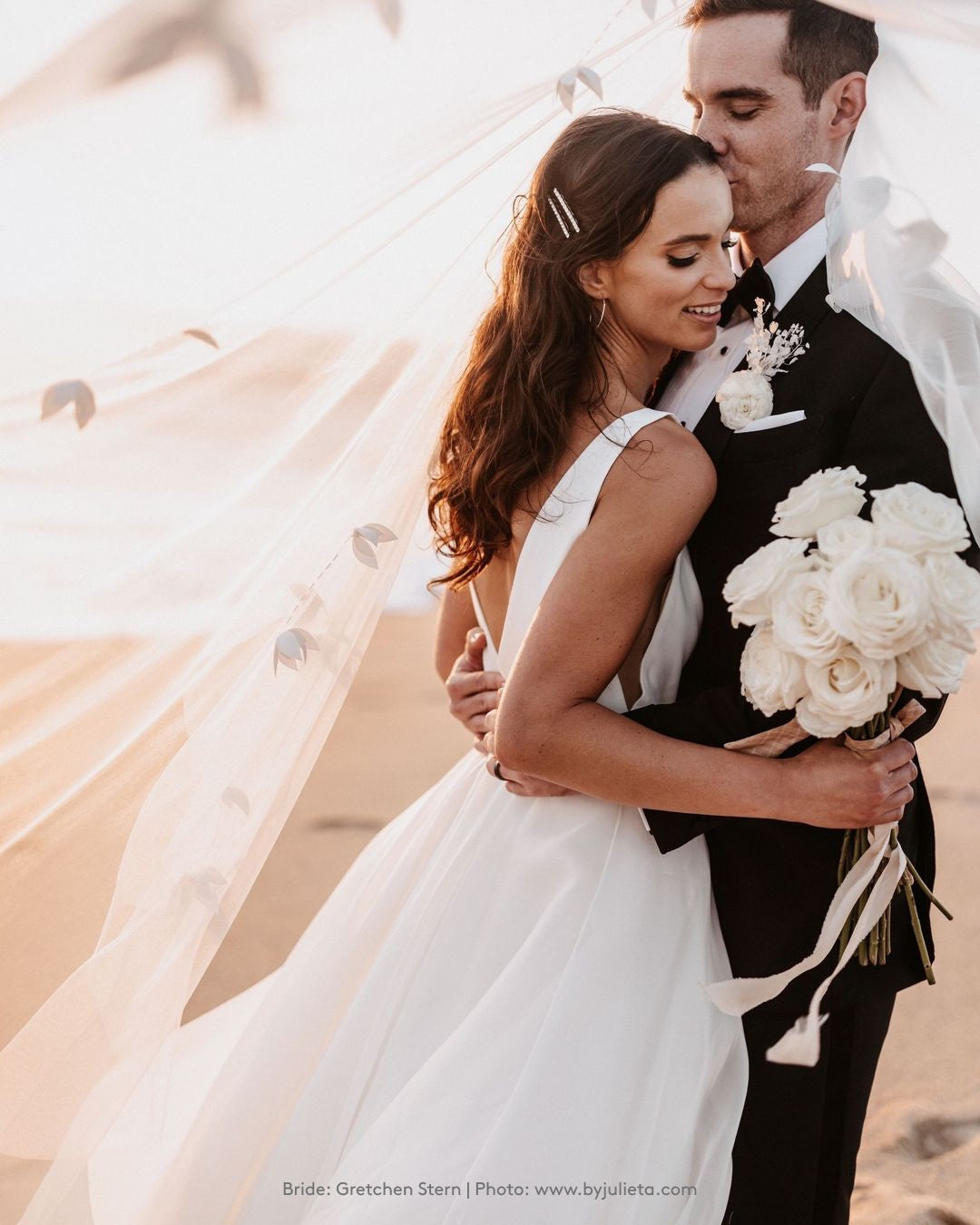 A bride and groom embracing on the beach