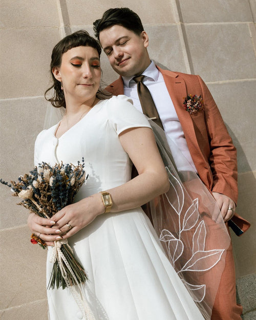 Modern bride and groom photo featuring fingertip-length floral wedding veil