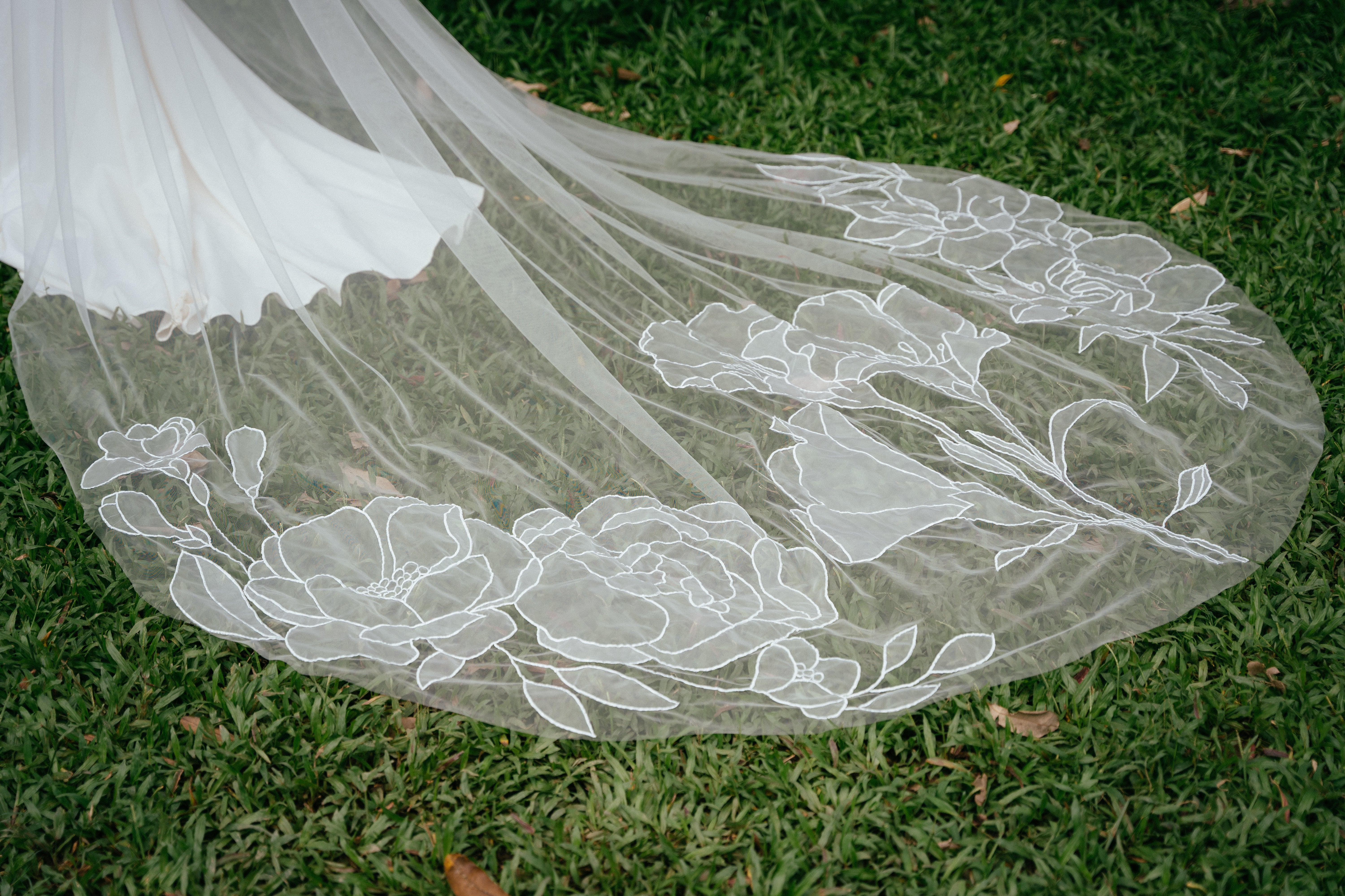The blusher and bottom of the JESI drop veil, showing the intricate floral embroidery on the hemline.
