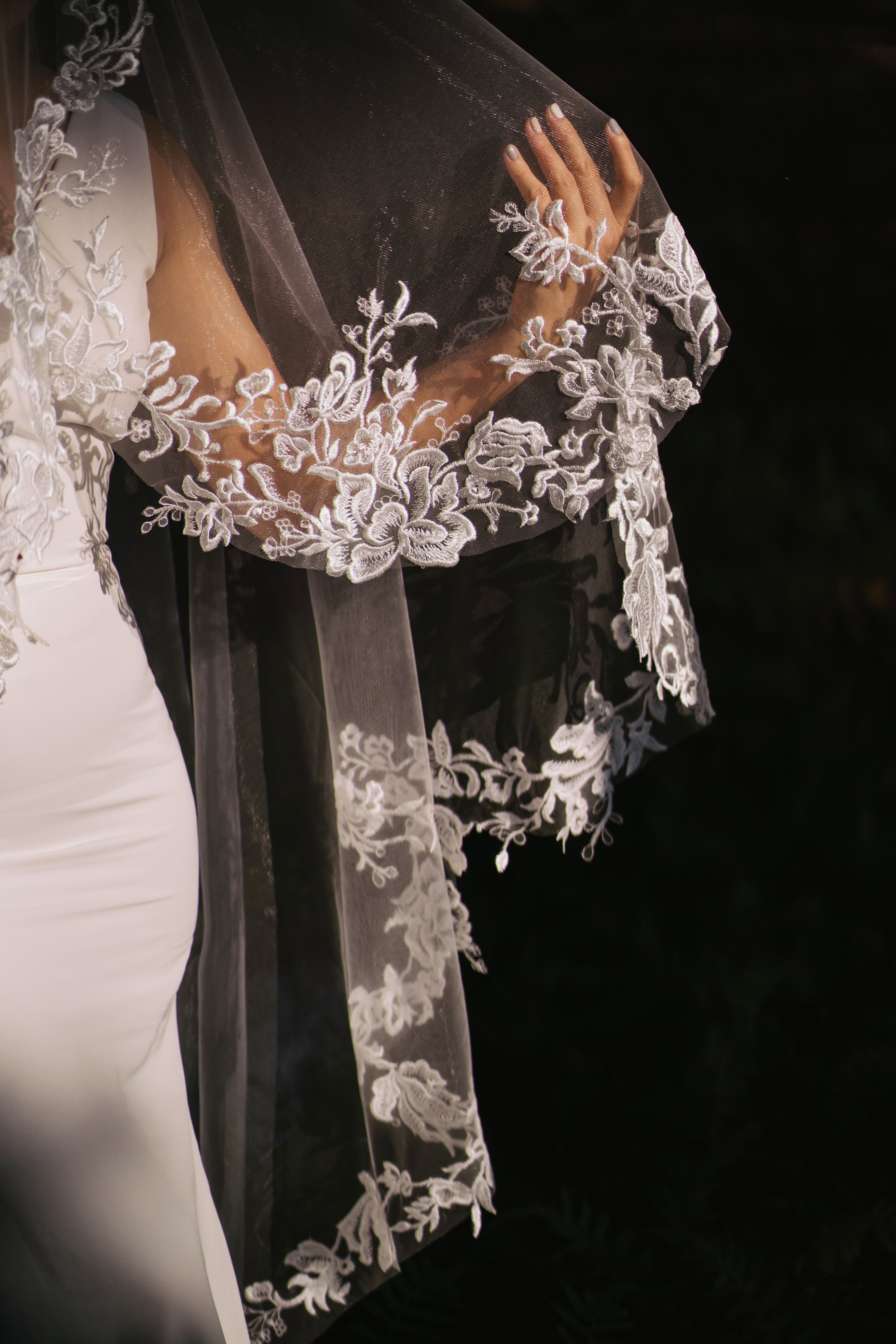 side view of Detailed view of the elegant lace embroidery on the "ELA" veil.
