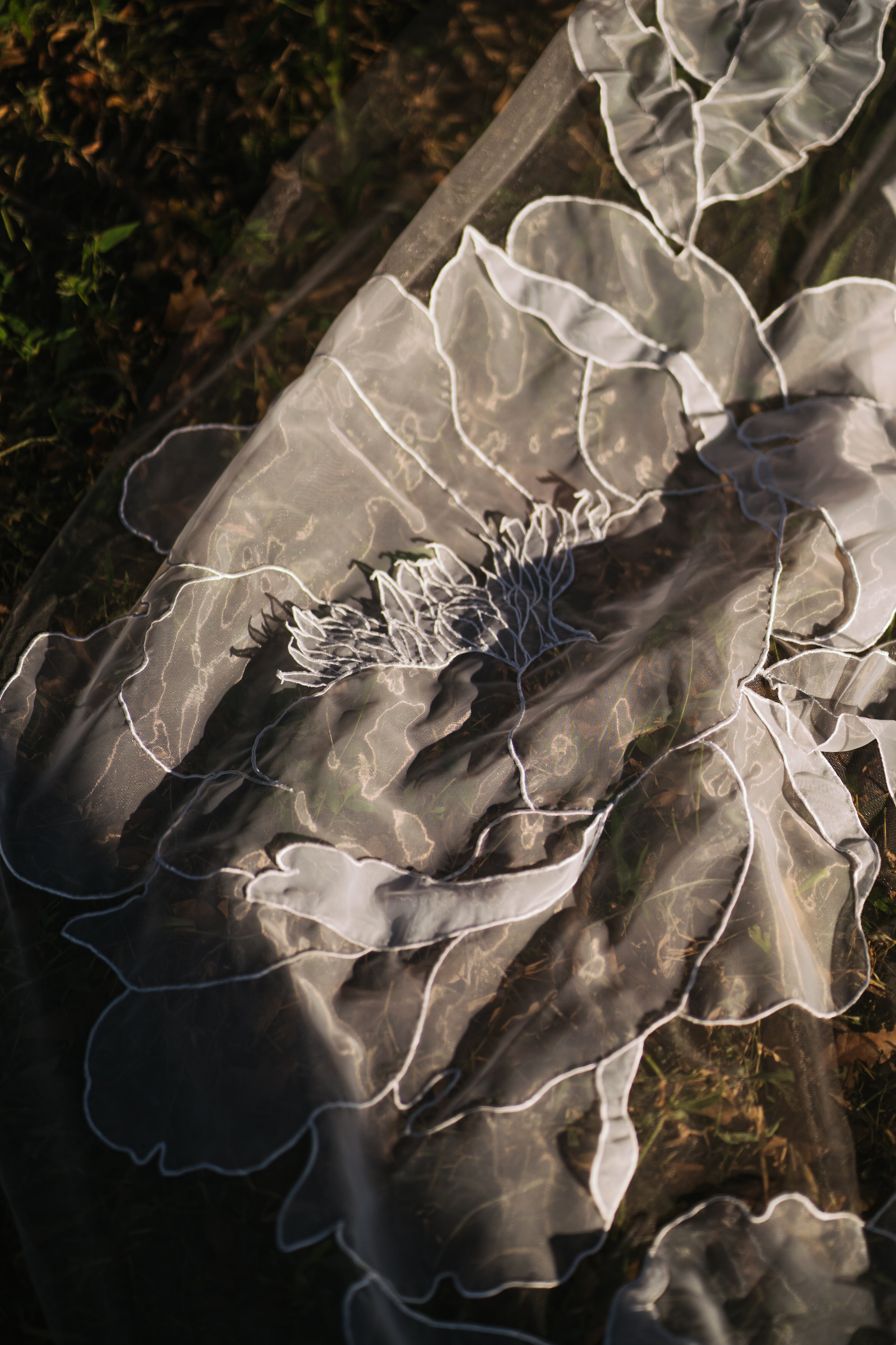 Detailed view of the "Gloriosa" 3D floral wedding veil's elegant train.

