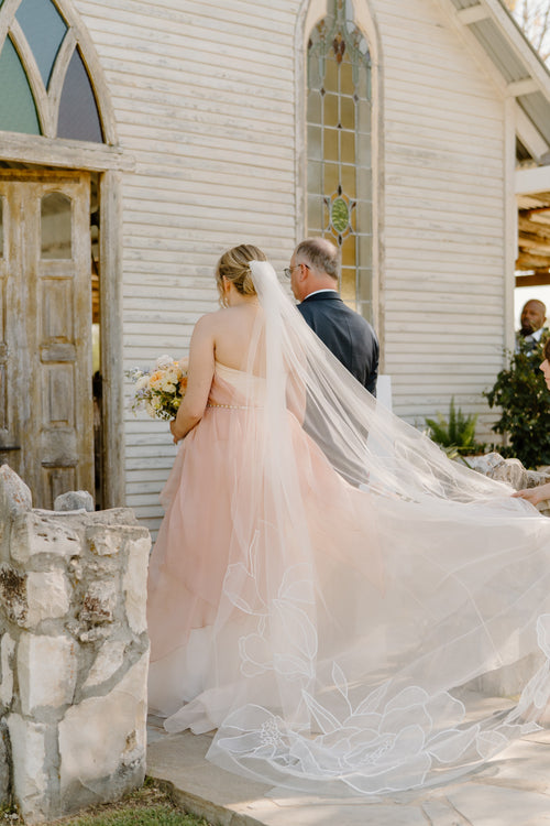 Kait Galligan bride wearing a chapel floral wedding veil and a dreamy pinky wedding dress