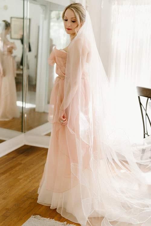 Kait Galligan bride wearing a chapel floral wedding veil and a dreamy pinky wedding dress