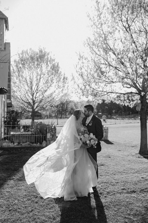 Kait Galligan bride wearing a chapel floral wedding veil and a dreamy pinky wedding dress