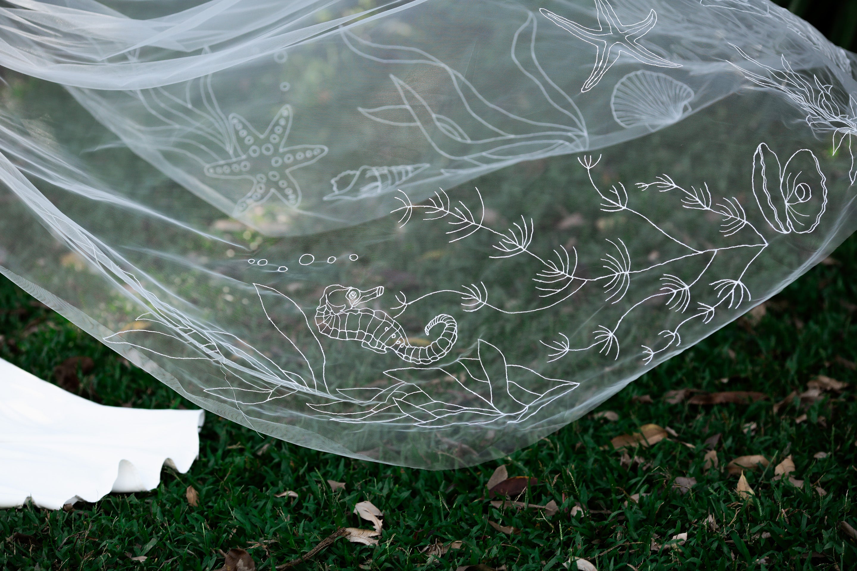 Ocean-inspired wedding veil with embroidered marine life featuring jellyfish, starfish, seahorses, and seaweed on organza fabric, perfect for beach weddings