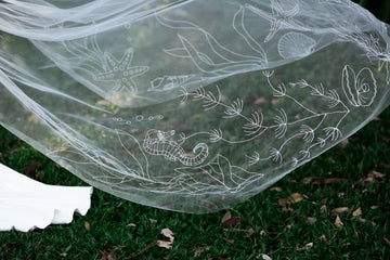 Ocean-inspired wedding veil with embroidered marine life featuring jellyfish, starfish, seahorses, and seaweed on organza fabric, perfect for beach weddings