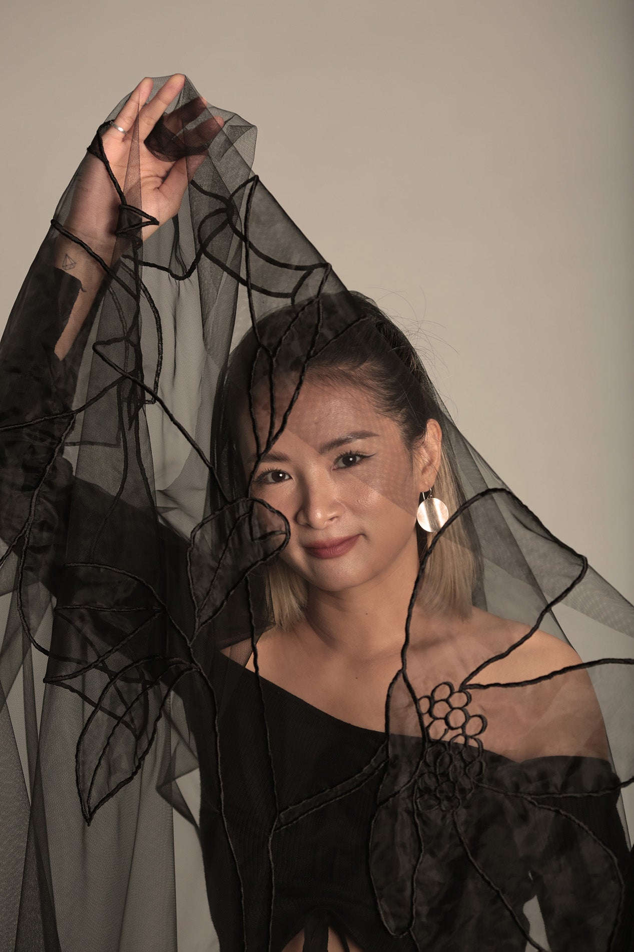close up picture of A bride wearing a stylish black wedding veil, highlighting the AUDREY design and its elegant drape.

