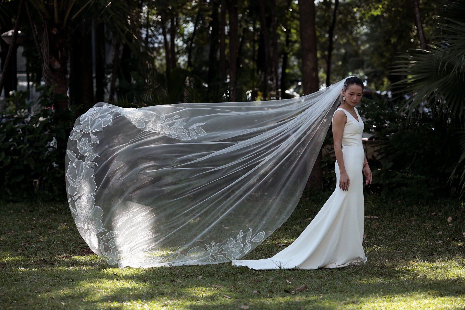 A bride wearing a beautiful cathedral-length SOPHIA veil, made of sheer organza and adorned with three-dimensional floral appliques.
Asia's cherry blossoms and Europe's wild roses, organza cathedral floral veil

