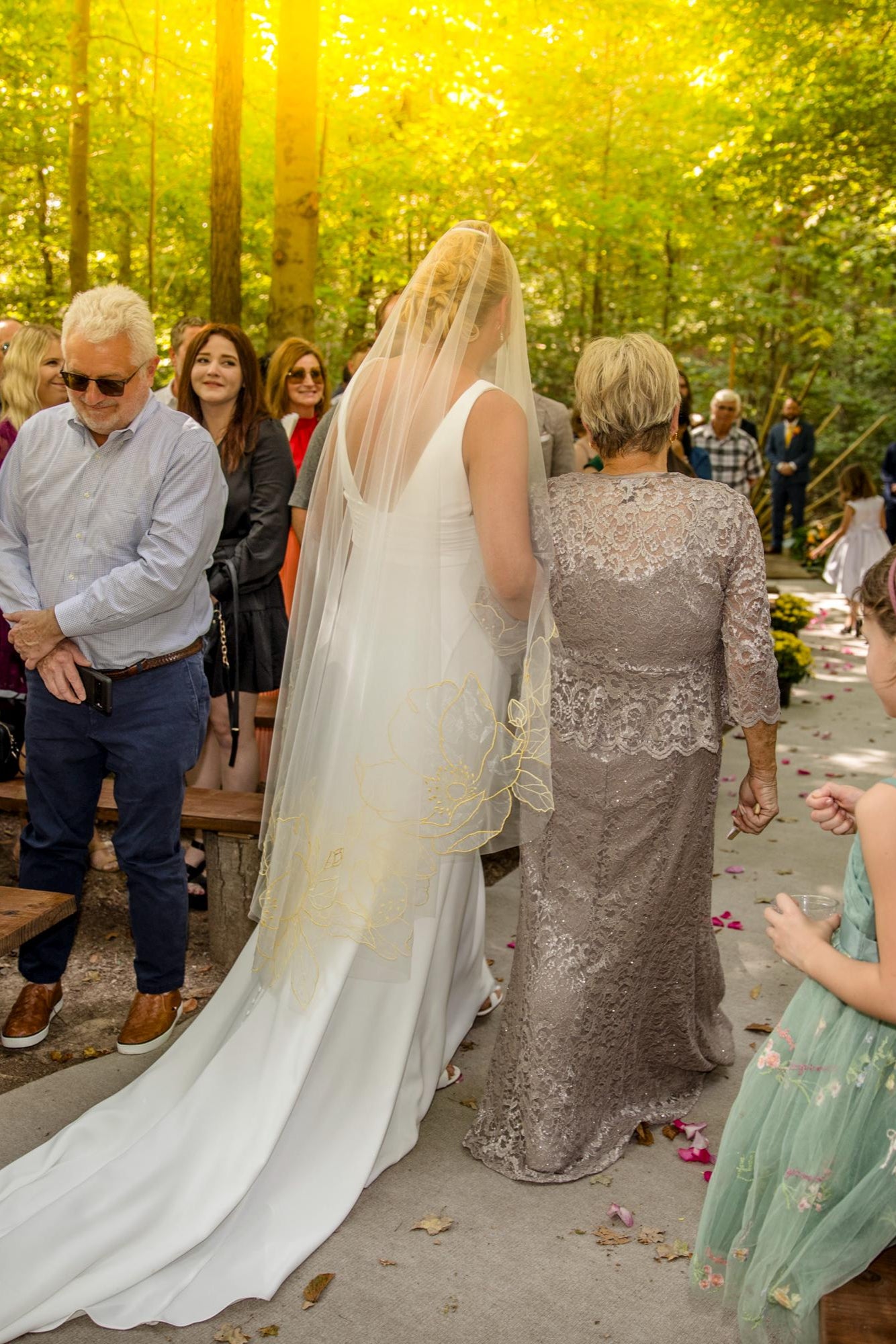 Organza fingertip length wedding veil with blooming vibrant yellow floral motifs, handcrafted by Tara Bridal, bride walks down the aisle with bride's mom