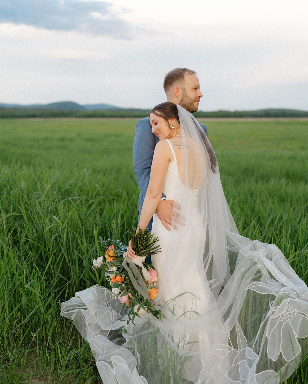 A bride and groom standing in a field