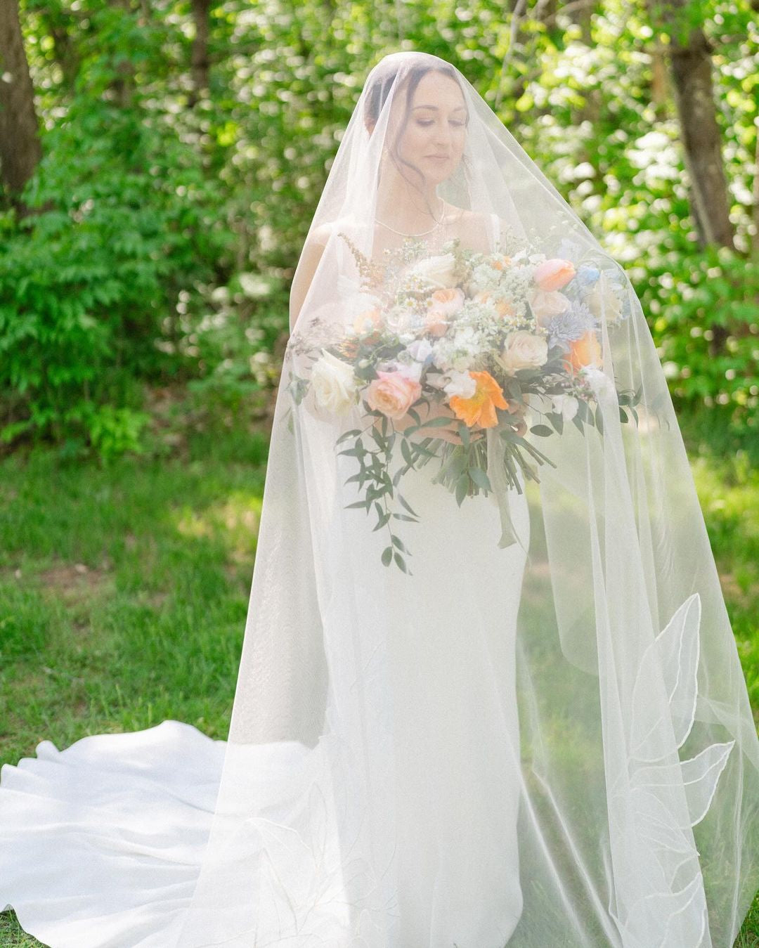 A woman in a white wedding dress holding a bouquet of flowers